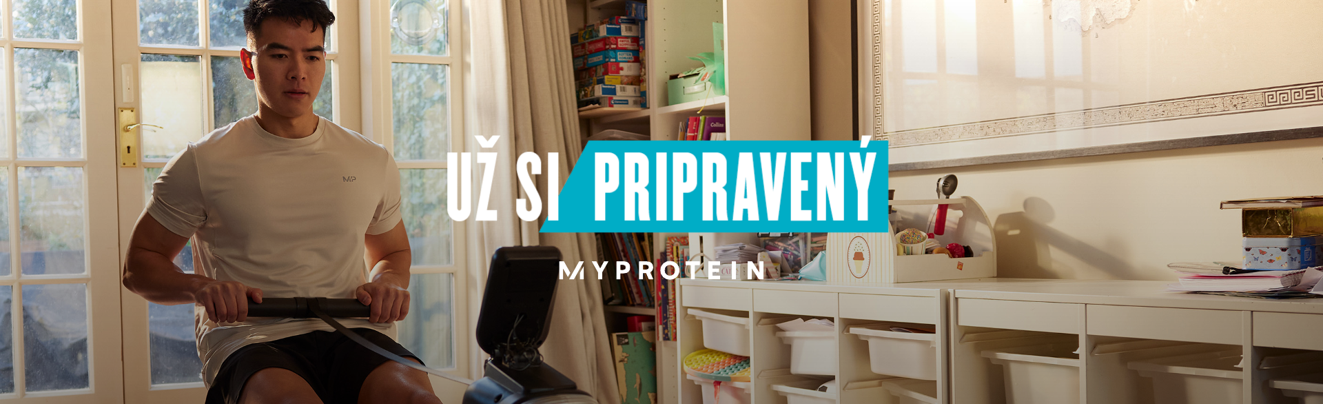 A man workout out on a rowing machine at home with the words 'You're Already Ready - MYPROTEIN' overlaying.