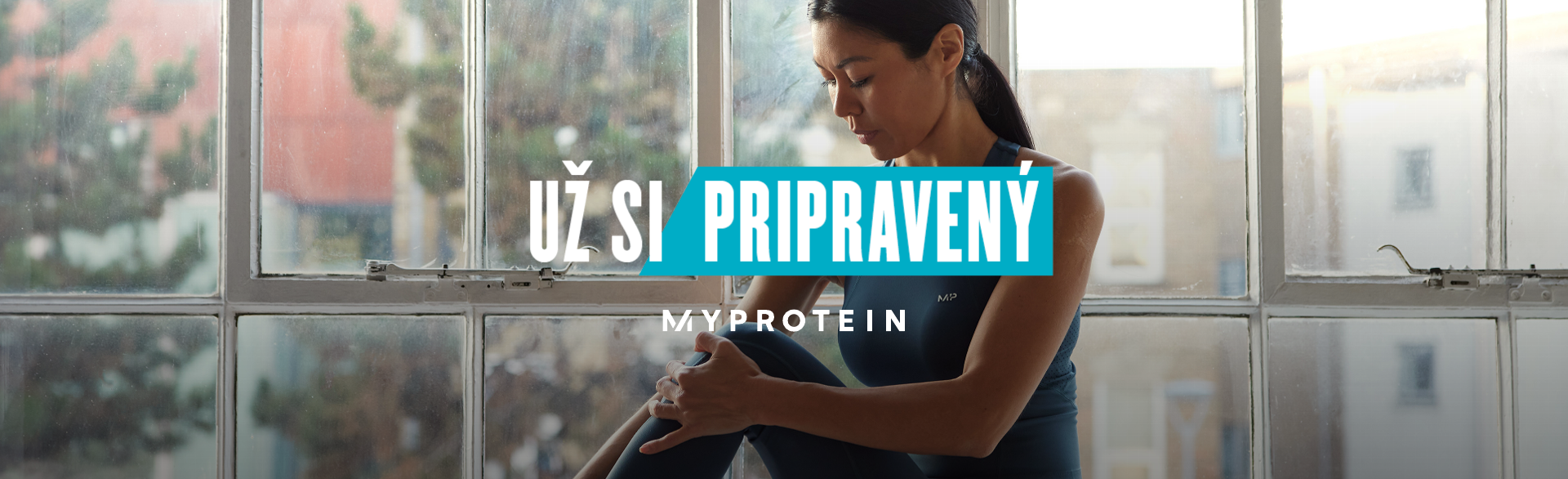 A woman wearing MP gym clothing sat on a window ledge stretching with the text 'You're Already Ready - MYPROTEIN' overlaying the image.